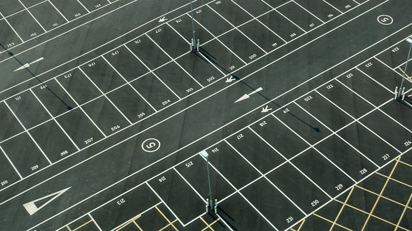 Aerial view of an empty car park with numbered bays and white line markings