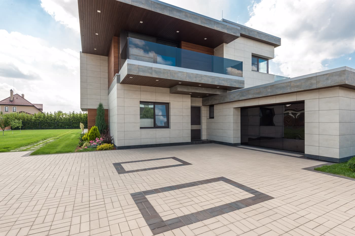 A large paved forecourt with an inlaid border pattern in front of a modern building