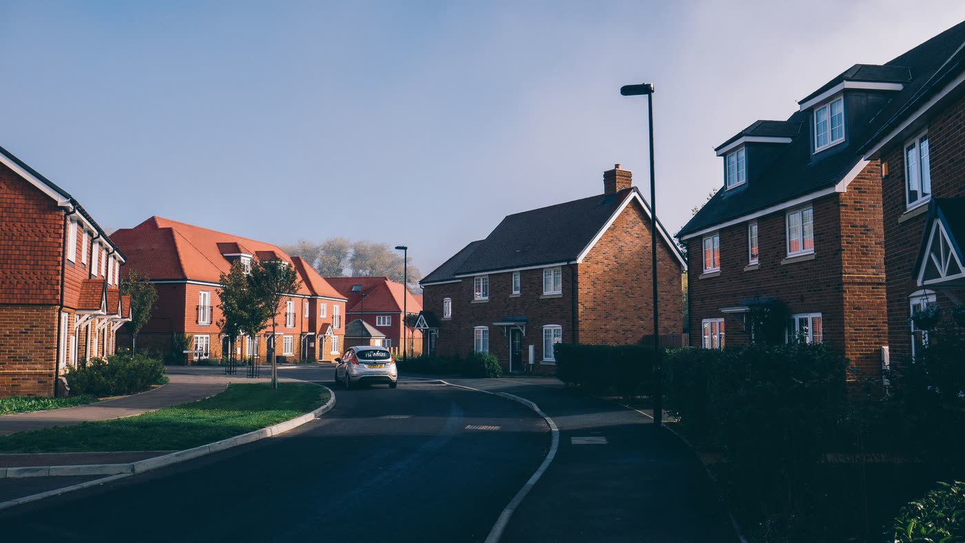 An English suburban street of red-brick houses on a still morning