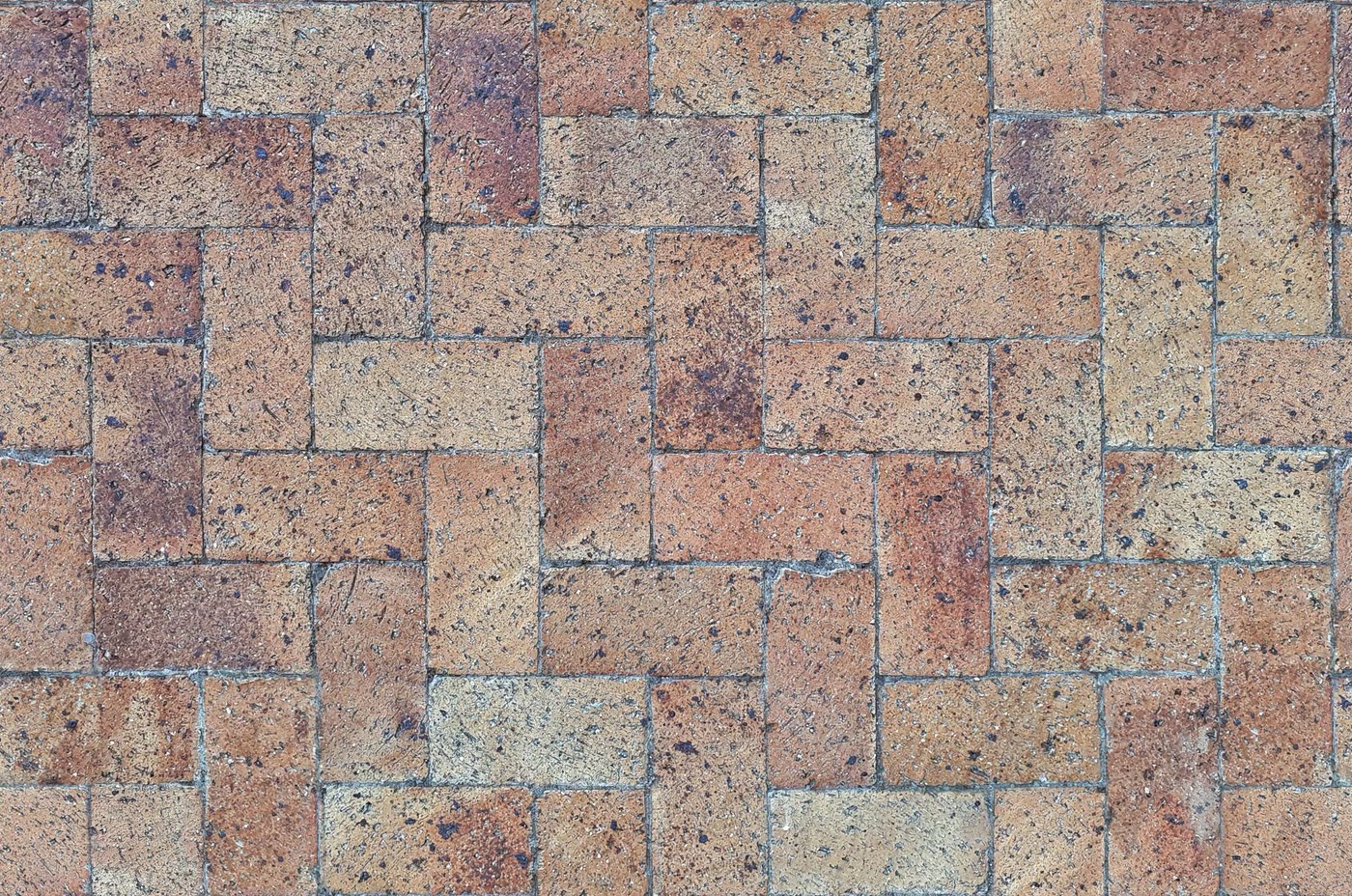 Close-up of clay-coloured paving blocks laid in a herringbone bond