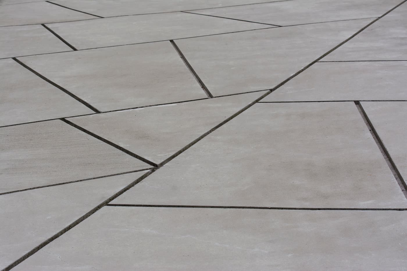 Large-format concrete paving with cut induced joints running between the bays