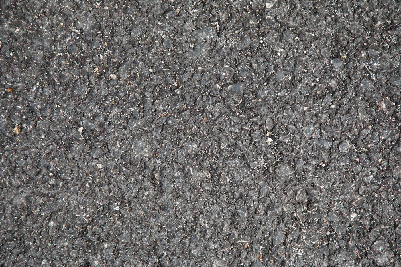 Close-up of a dark asphalt surface showing its granular texture